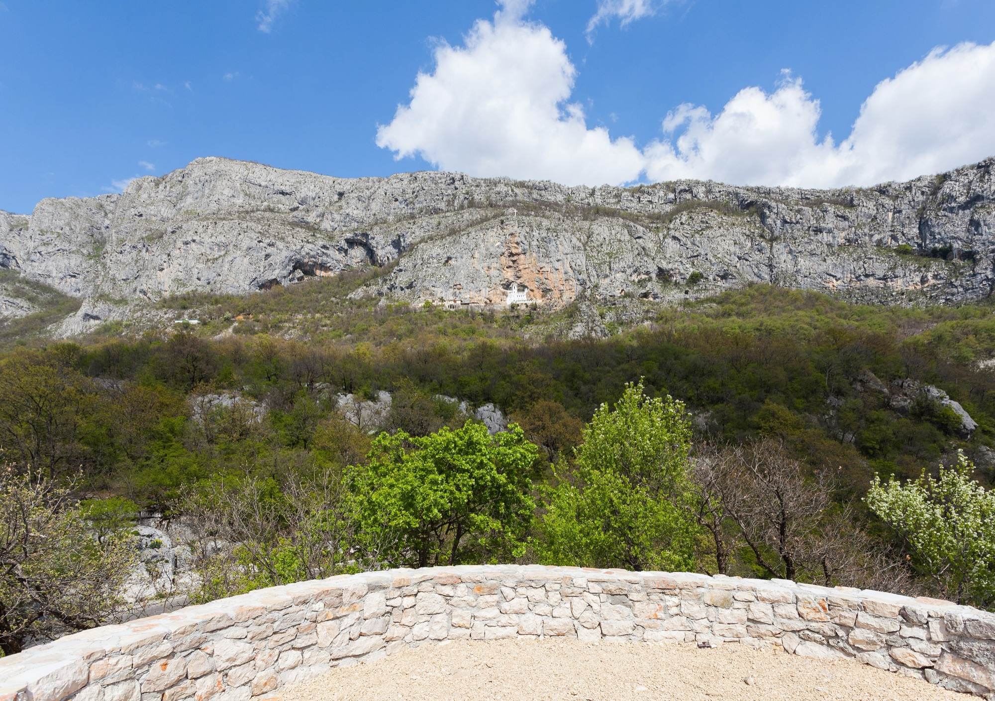 The long cliff of Ostroška Greda with the small white monastery high in the rock