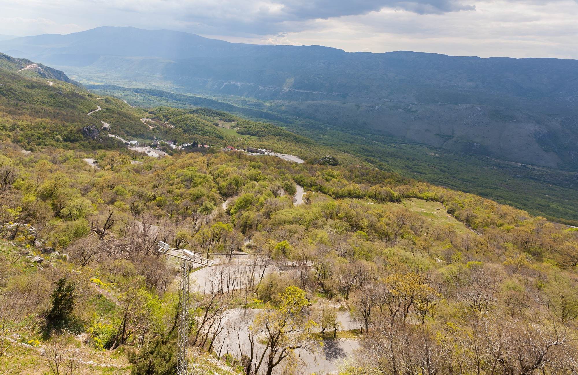 The winding road climbing the hillside below Ostrog Monastery, with mountains beyond